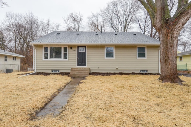 view of front of property featuring entry steps, a front yard, fence, and roof with shingles