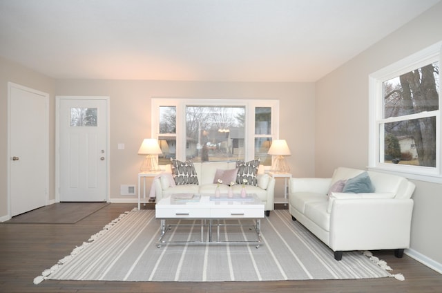 living room featuring visible vents, baseboards, and wood finished floors