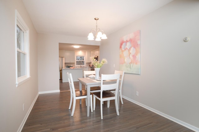 dining room with baseboards, dark wood finished floors, and a chandelier