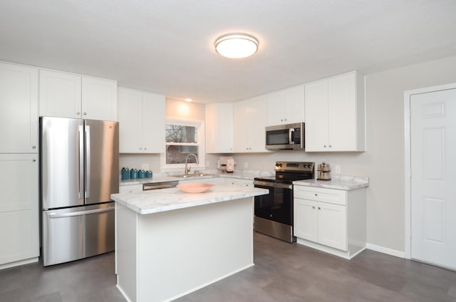 kitchen featuring a center island, stainless steel appliances, white cabinets, a sink, and baseboards