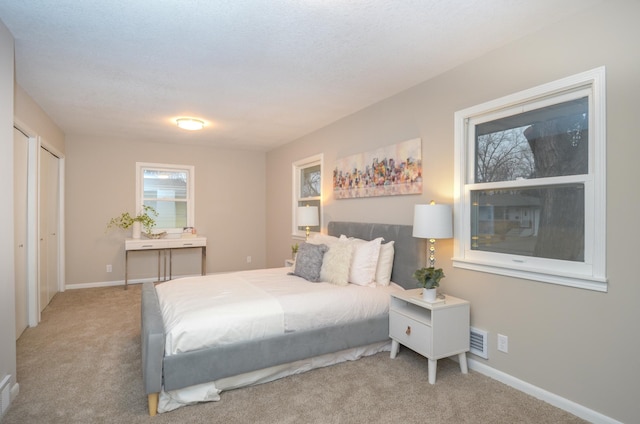 carpeted bedroom with baseboards and visible vents