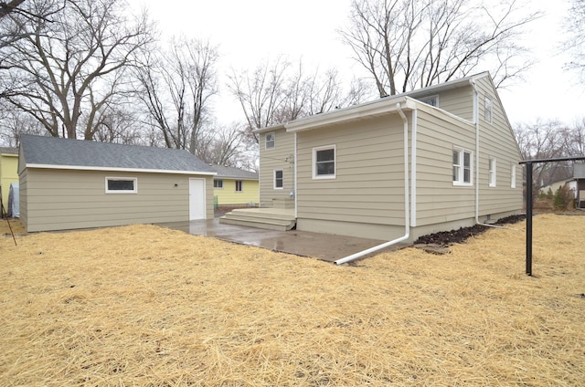 back of property with a patio area and an outbuilding