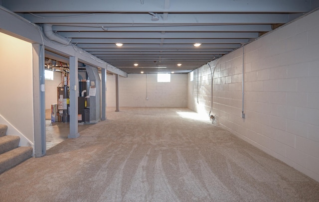 basement featuring water heater, stairway, carpet flooring, and heating unit