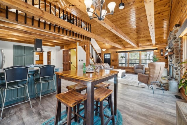 11669 Dellwood Rd, Grant, MN 55082 - dining room with wood finished floors, a chandelier, stairway, wooden ceiling with exposed beams, and log walls