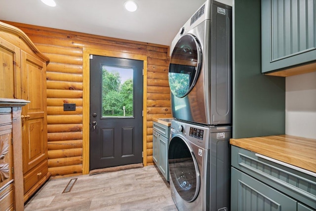 11669 Dellwood Rd, Grant, MN 55082 - laundry area featuring estacked washer and dryer, cabinet space, log walls, light wood-style flooring, and recessed lighting