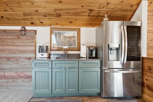 11669 Dellwood Rd, Grant, MN 55082 - kitchen featuring stainless steel fridge with ice dispenser, a sink, wood ceiling, wooden walls, and blue cabinetry