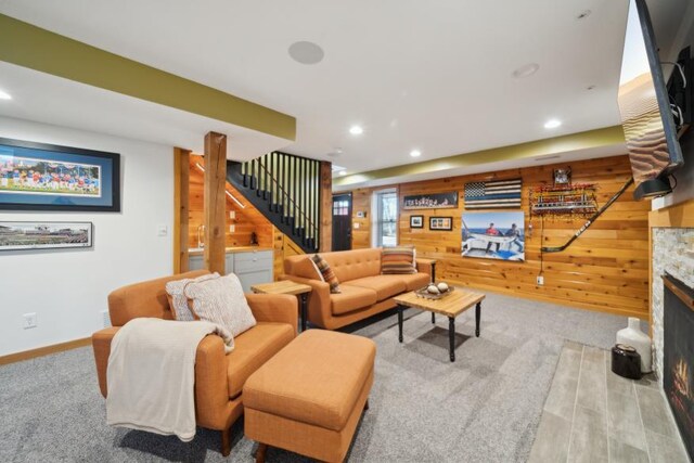 11669 Dellwood Rd, Grant, MN 55082 - carpeted living room with wood walls, stairs, a stone fireplace, recessed lighting, and baseboards