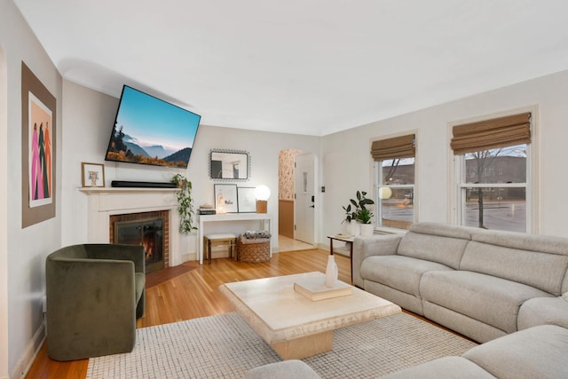 living area with a fireplace, wood finished floors, and baseboards