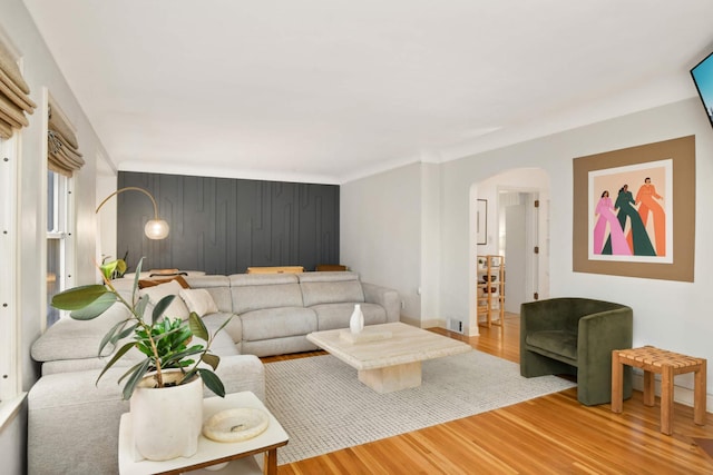 living area with arched walkways, visible vents, and wood finished floors