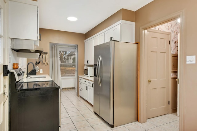 kitchen featuring stainless steel fridge, range with electric cooktop, extractor fan, white cabinetry, and a sink