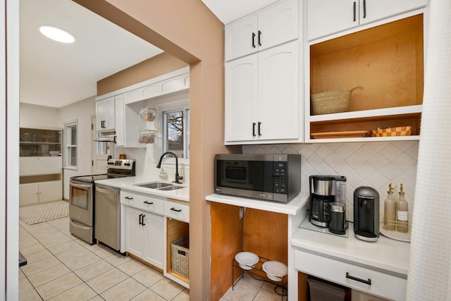 kitchen featuring white cabinetry, appliances with stainless steel finishes, decorative backsplash, and a sink