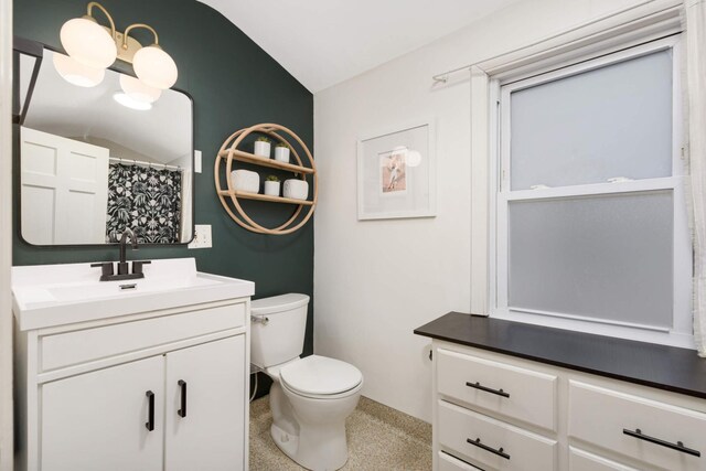 bathroom featuring toilet, speckled floor, a shower with shower curtain, and vanity