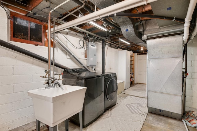 laundry area featuring a sink, laundry area, electric panel, and washer and dryer