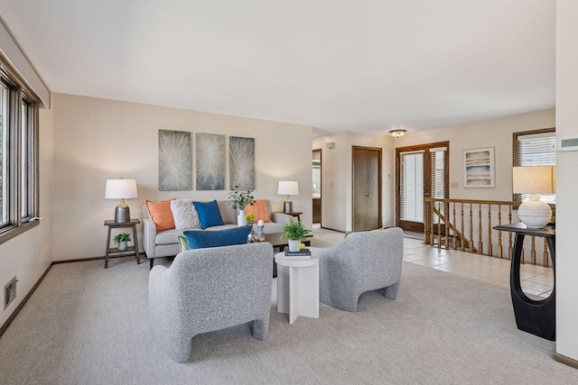 living area featuring light tile patterned floors, visible vents, light carpet, and baseboards