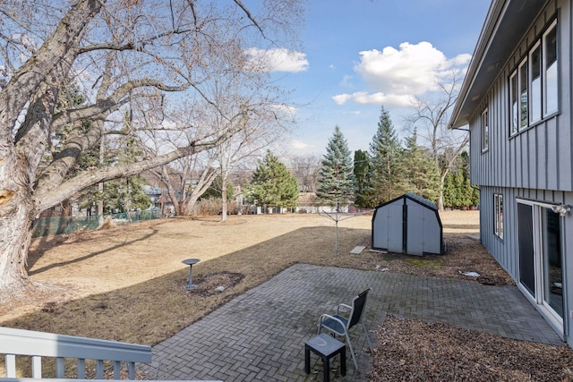 view of yard featuring a storage shed, a patio, fence, and an outdoor structure