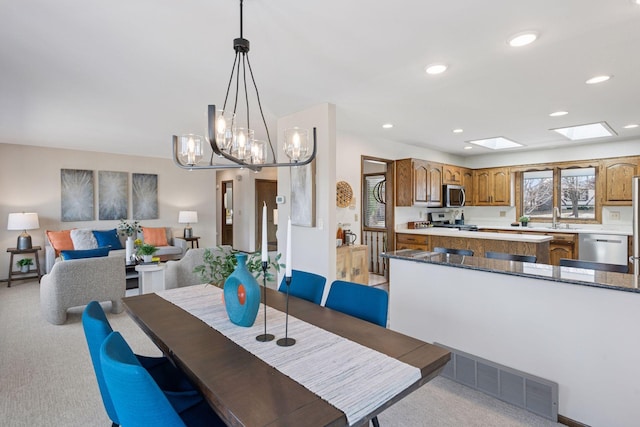 dining room featuring a skylight, visible vents, recessed lighting, and light colored carpet