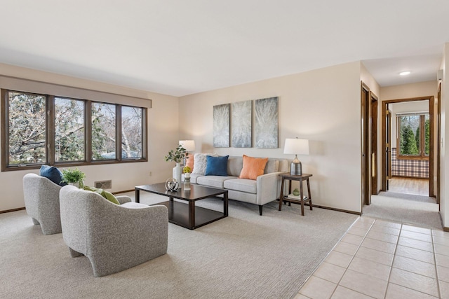 living room with light carpet, light tile patterned floors, plenty of natural light, and baseboards