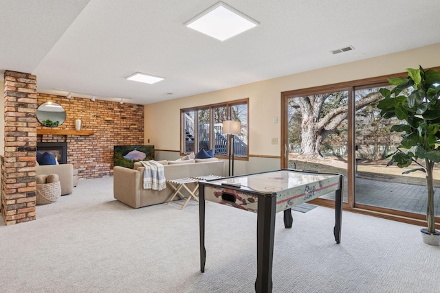 playroom with visible vents, plenty of natural light, a fireplace, and carpet floors