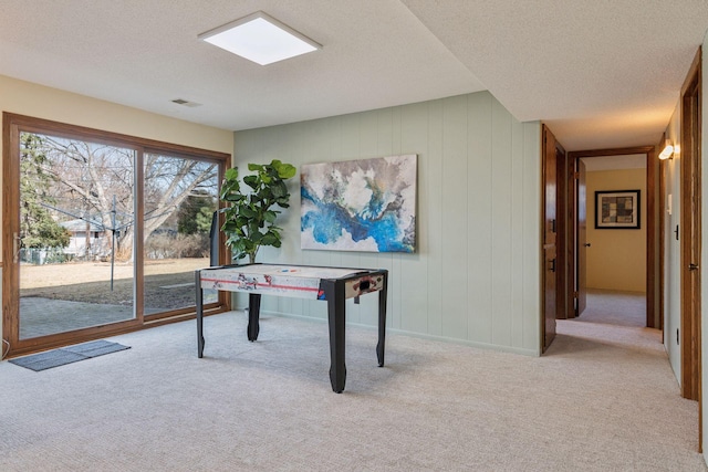 recreation room featuring carpet floors and a textured ceiling