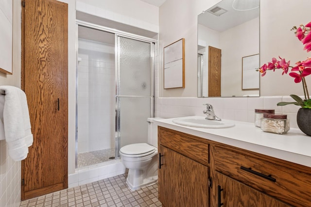 bathroom featuring visible vents, backsplash, a shower stall, toilet, and vanity