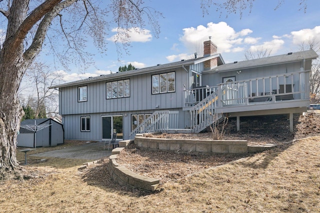 back of house featuring an outbuilding, a patio, stairway, a wooden deck, and a chimney