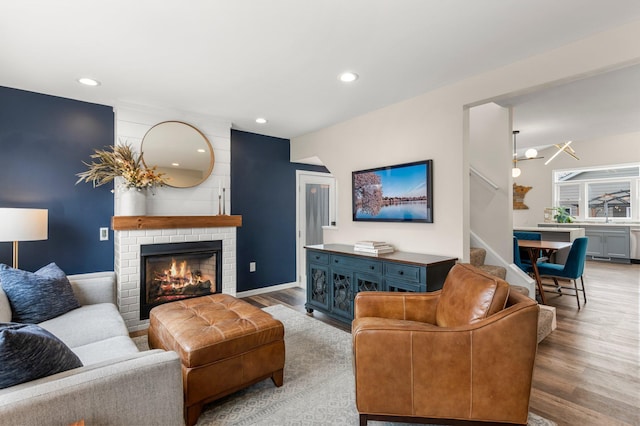 living area featuring recessed lighting, stairway, wood finished floors, and a fireplace