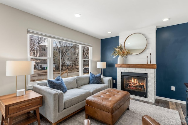 living area featuring a fireplace, recessed lighting, wood finished floors, and baseboards