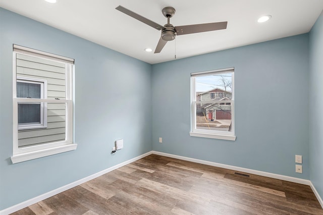 empty room with recessed lighting, wood finished floors, visible vents, and baseboards