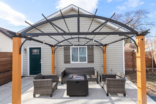 view of patio with an outdoor living space with a fire pit and fence