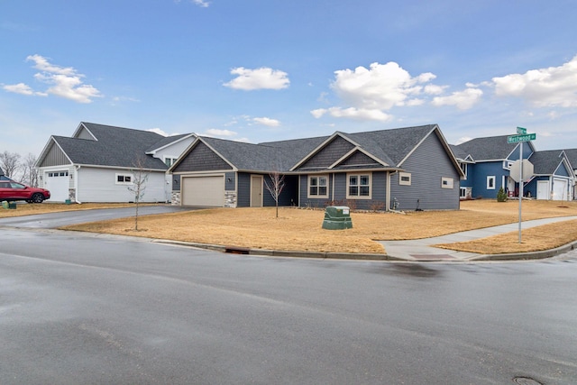 view of front of house with driveway, stone siding, and a garage