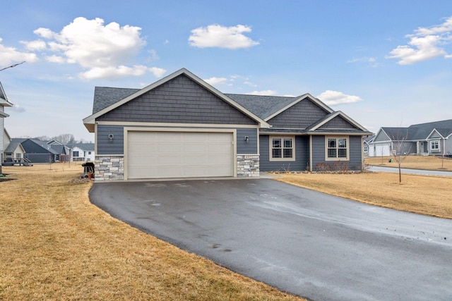 craftsman house with a front yard, stone siding, driveway, and an attached garage