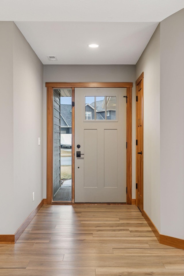 entryway featuring light wood-type flooring, visible vents, and baseboards