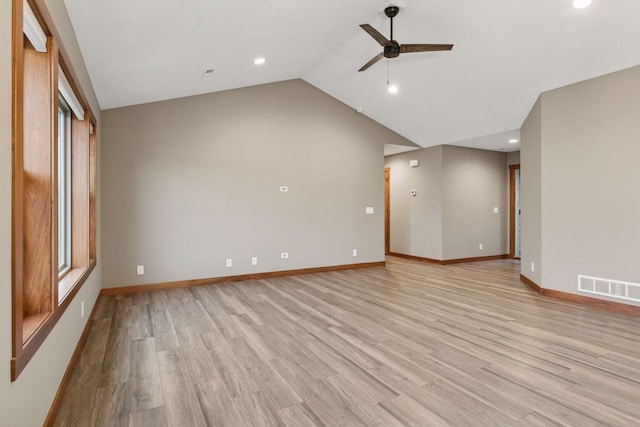 spare room with light wood-style flooring, visible vents, vaulted ceiling, and baseboards