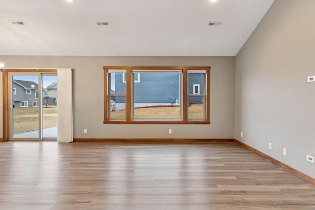 unfurnished room with visible vents, baseboards, and wood finished floors