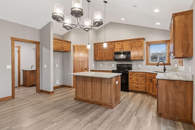 kitchen with light stone counters, a sink, light wood-style floors, brown cabinets, and black appliances