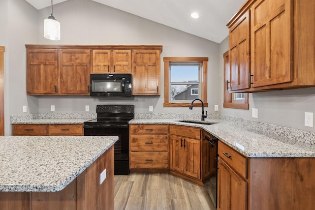 kitchen featuring lofted ceiling, black appliances, brown cabinetry, and a sink