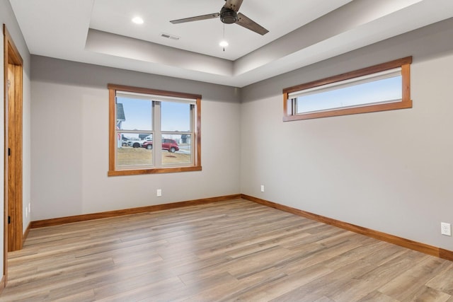 empty room featuring light wood-style floors, baseboards, and visible vents