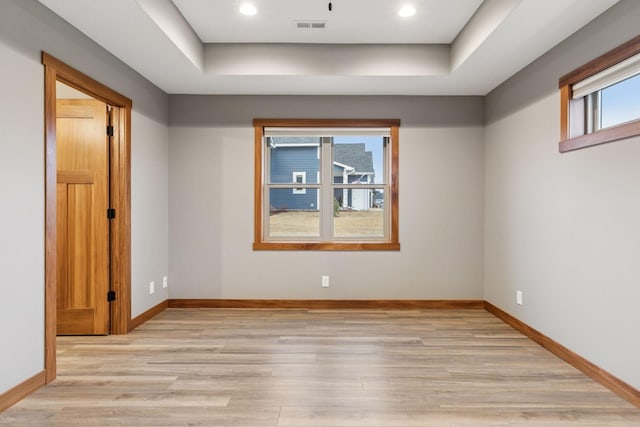 spare room with light wood finished floors, recessed lighting, visible vents, and baseboards