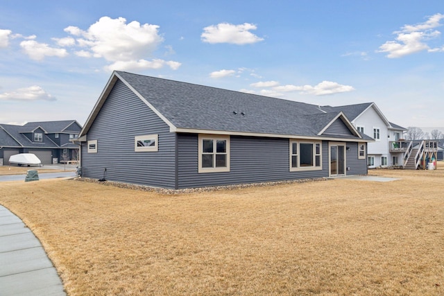 exterior space with a yard and roof with shingles