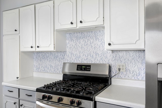 kitchen with decorative backsplash, white cabinetry, stainless steel appliances, and light countertops