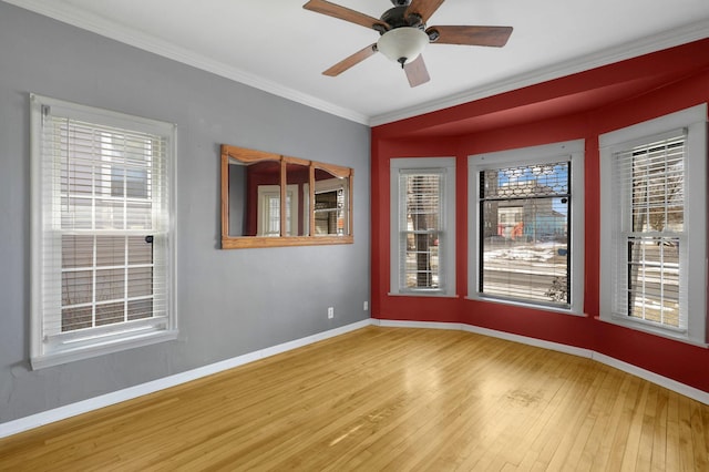 unfurnished room with hardwood / wood-style flooring, a ceiling fan, baseboards, and ornamental molding