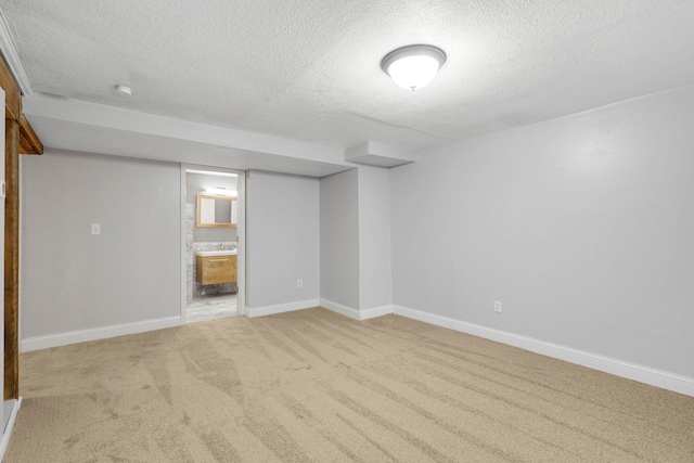 finished basement with carpet flooring, a textured ceiling, and baseboards