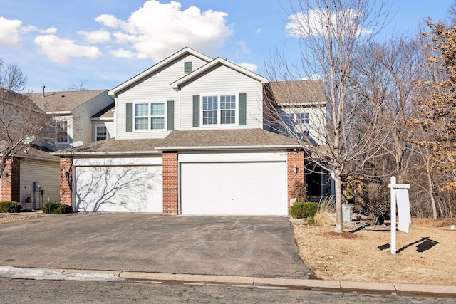 view of front of home with an attached garage, a shingled roof, aphalt driveway, and brick siding