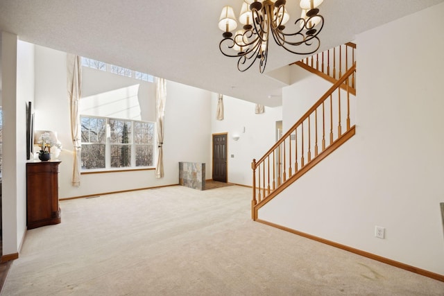 living room featuring carpet, stairs, and a chandelier