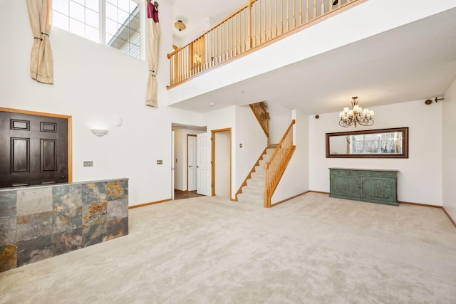 carpeted living room with a chandelier, a towering ceiling, stairway, and baseboards