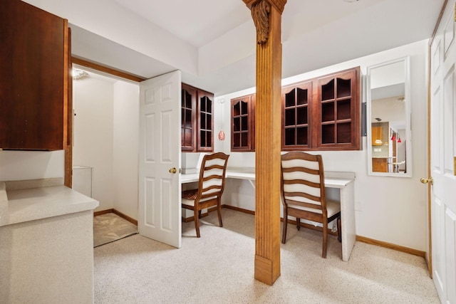 home office featuring baseboards and built in desk