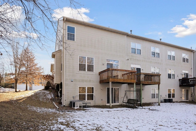 snow covered property with central AC