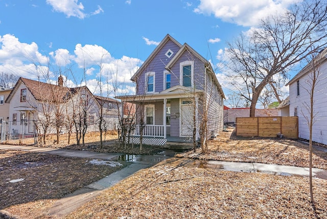 view of front of property featuring a porch and fence