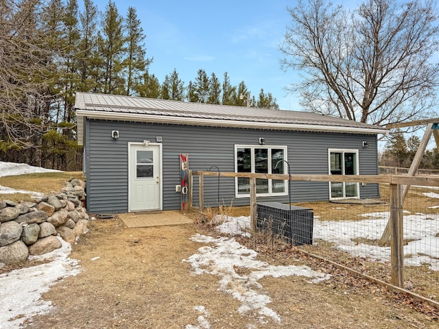 exterior space with metal roof and fence