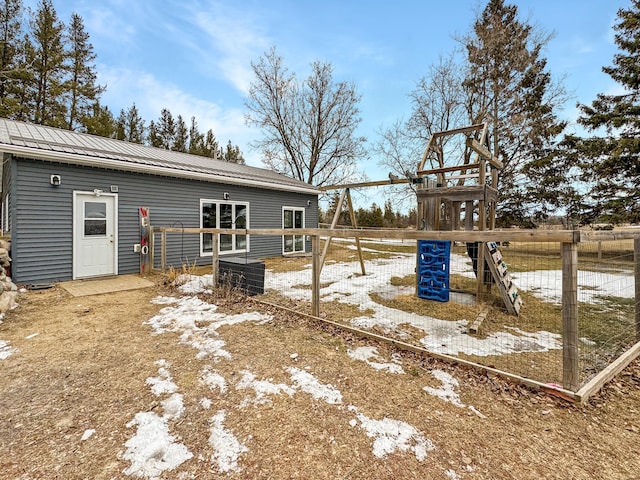 back of property featuring metal roof and a playground